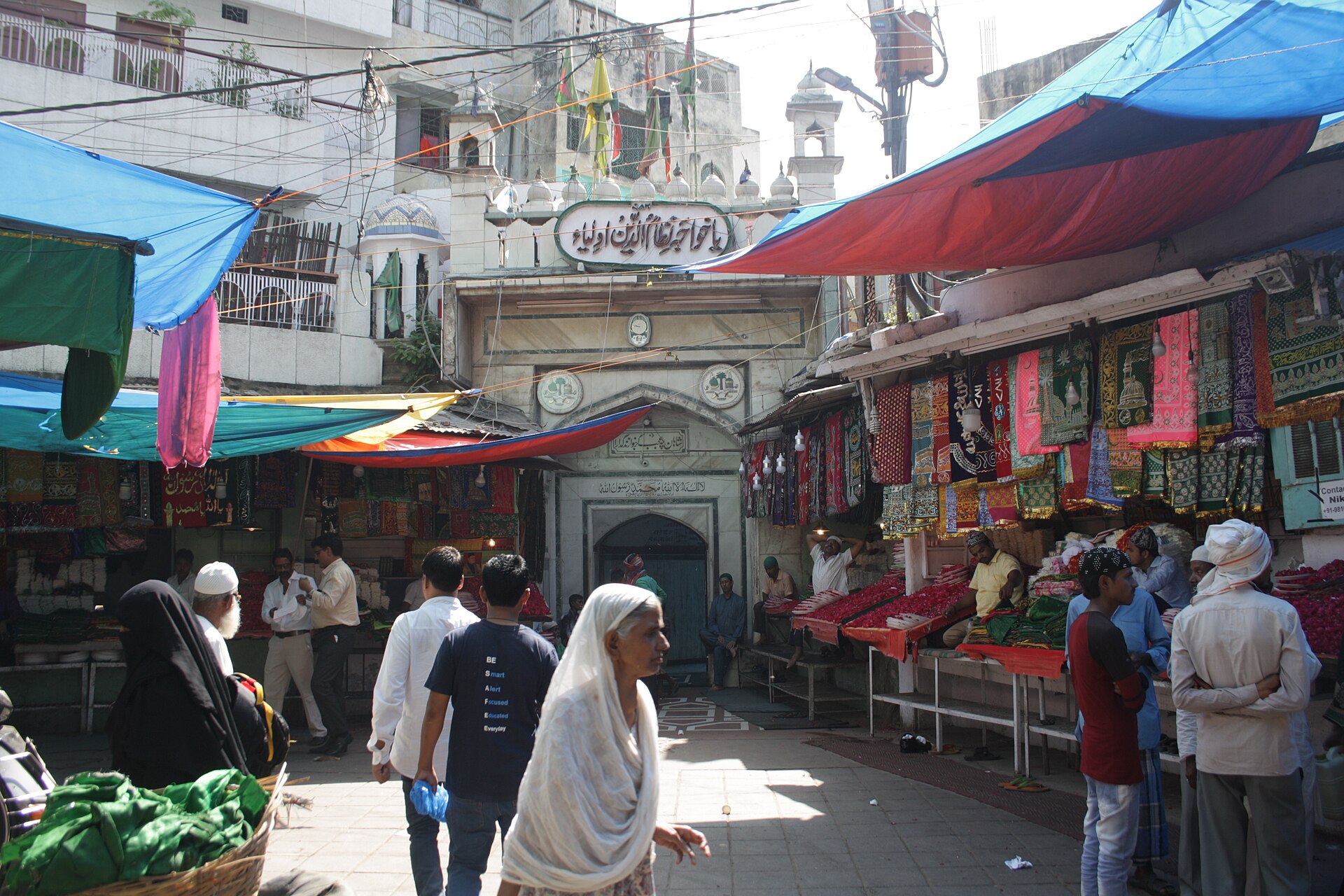 Delhi Sufi Music | The India A lively street market bustles near the entrance to a mosque, showcasing Indian culture.