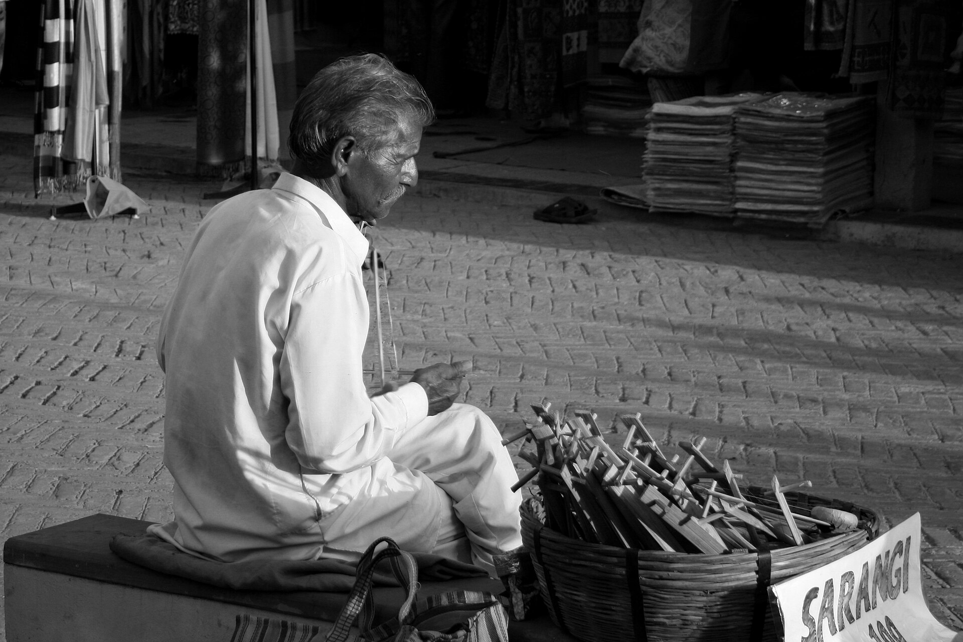 Hindustani Classical Music | The India An elderly man plays a sarangi instrument outdoors, showcasing traditional Indian music.