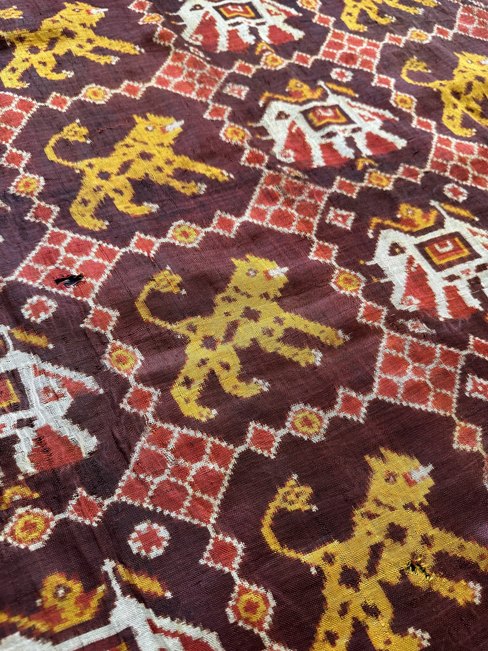 Ikat Textile | The India A detailed ikat textile showcases repeating animal and geometric motifs, representing traditional Indian art.