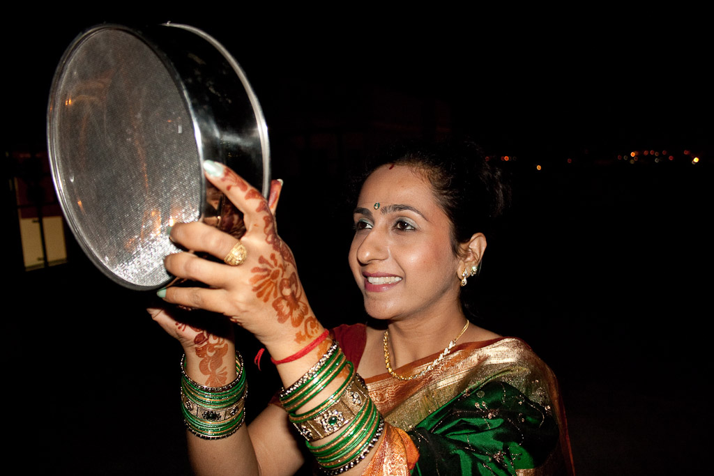 Karva Chauth | The India A woman views the moon through a sieve during the Karva Chauth festival, celebrating Indian culture and traditions.