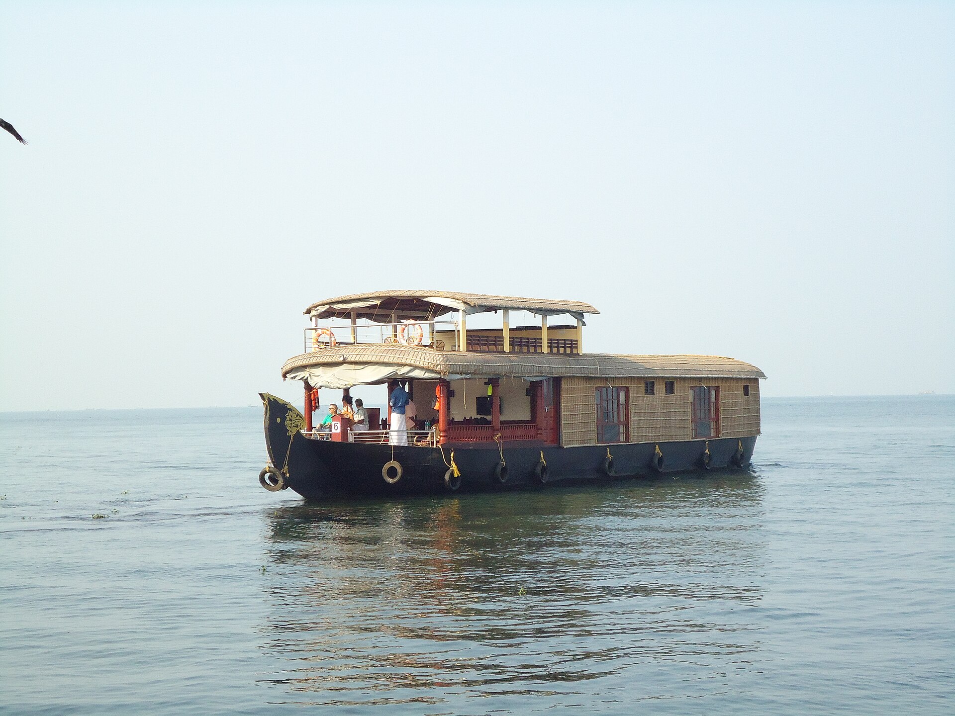 Kerala Backwaters | The India A houseboat floats on calm water in the Kerala backwaters, offering a unique travel experience.