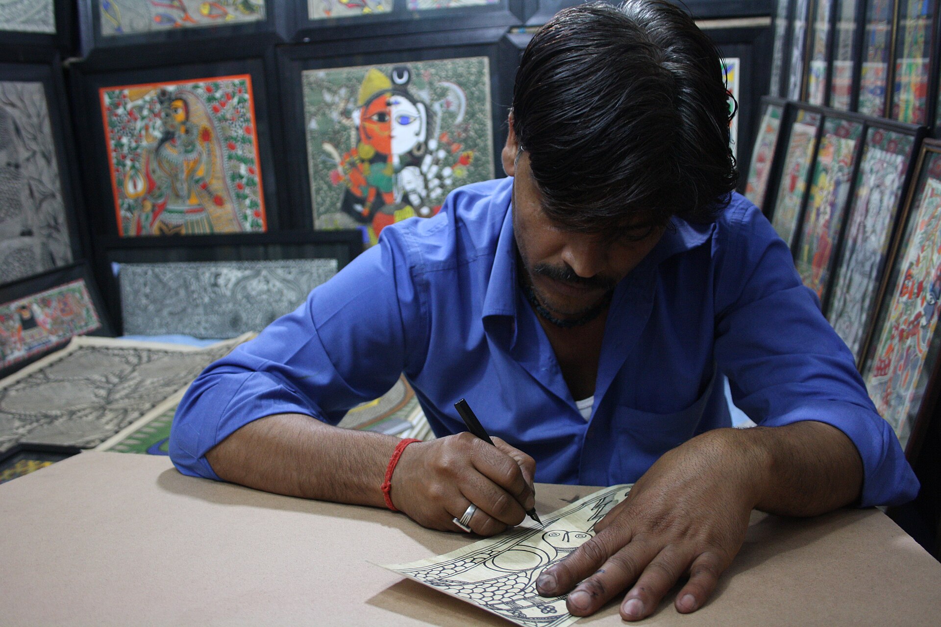 Madhubani Painting | The India An artist carefully draws a Madhubani painting in his workshop, showcasing traditional Indian art.