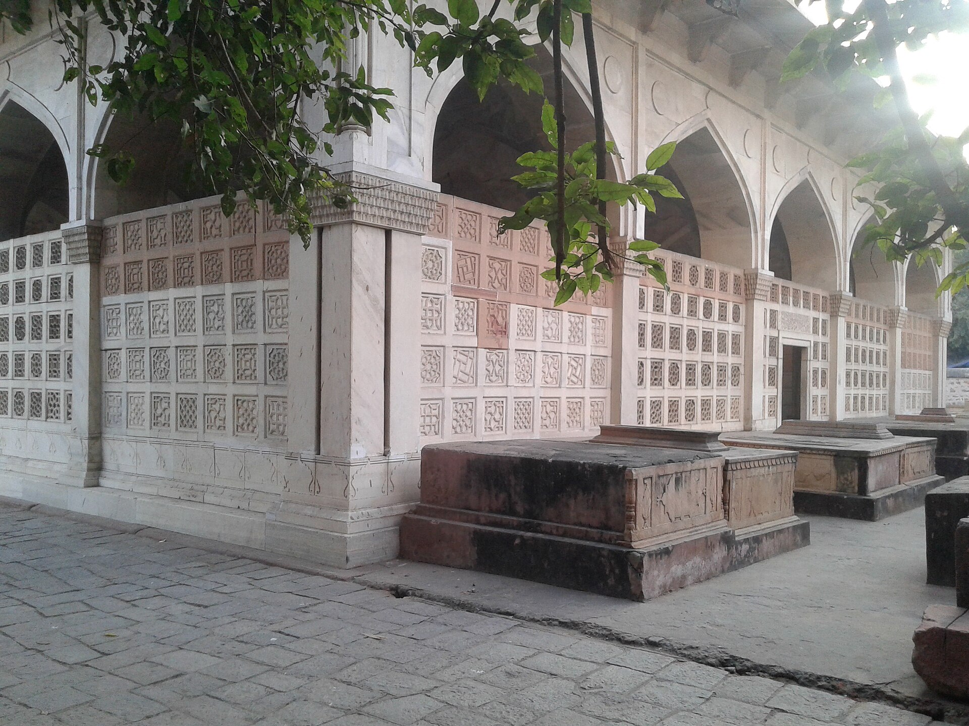 Mirza Galib Tomb | The India The exterior of Mirza Galib's tomb in Nizamuddin features intricate stonework and arched openings.