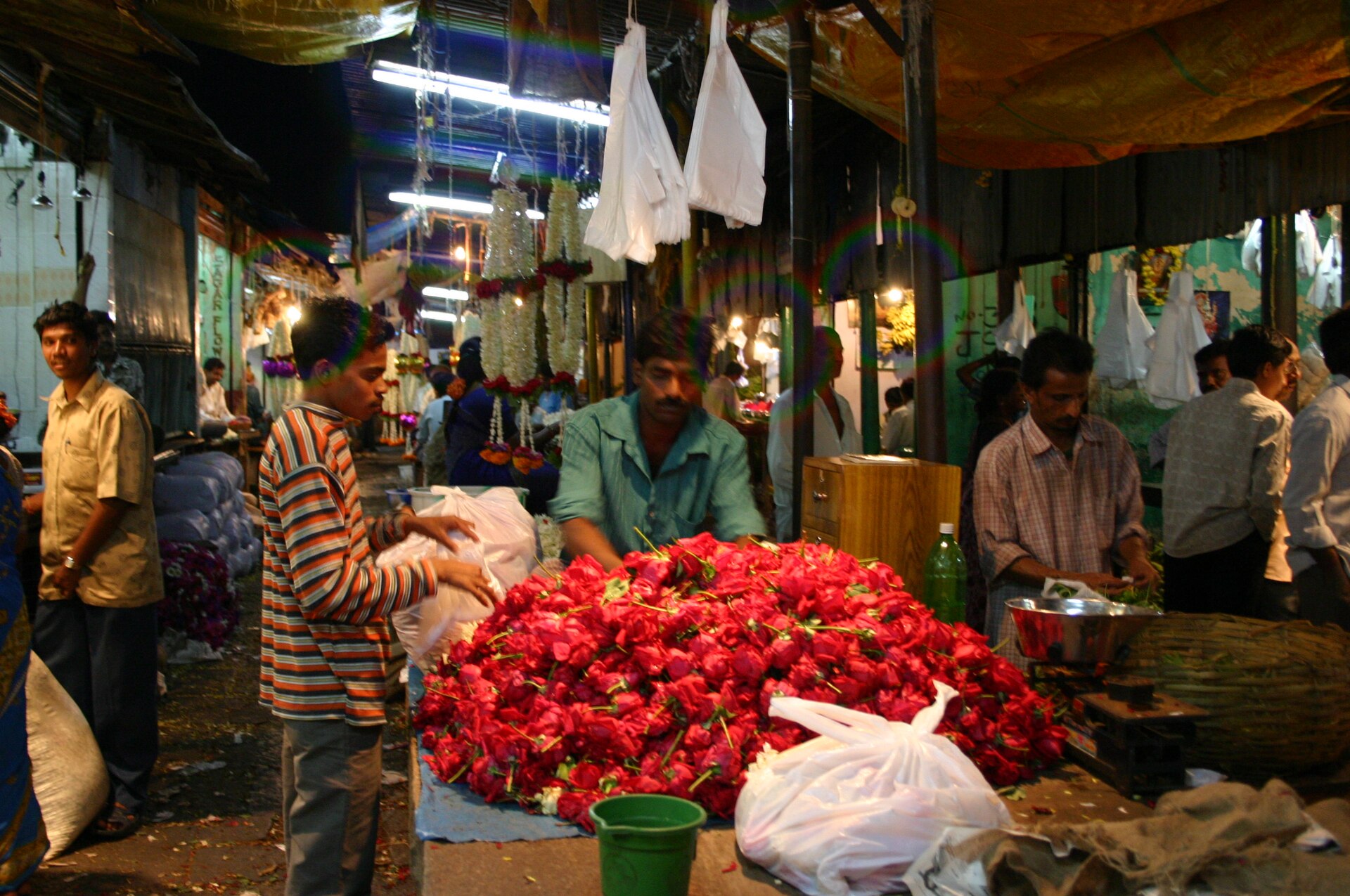 Devaraja Market | The India A bustling flower market in Mysore showcases vibrant red roses and busy vendors, reflecting Indian culture.