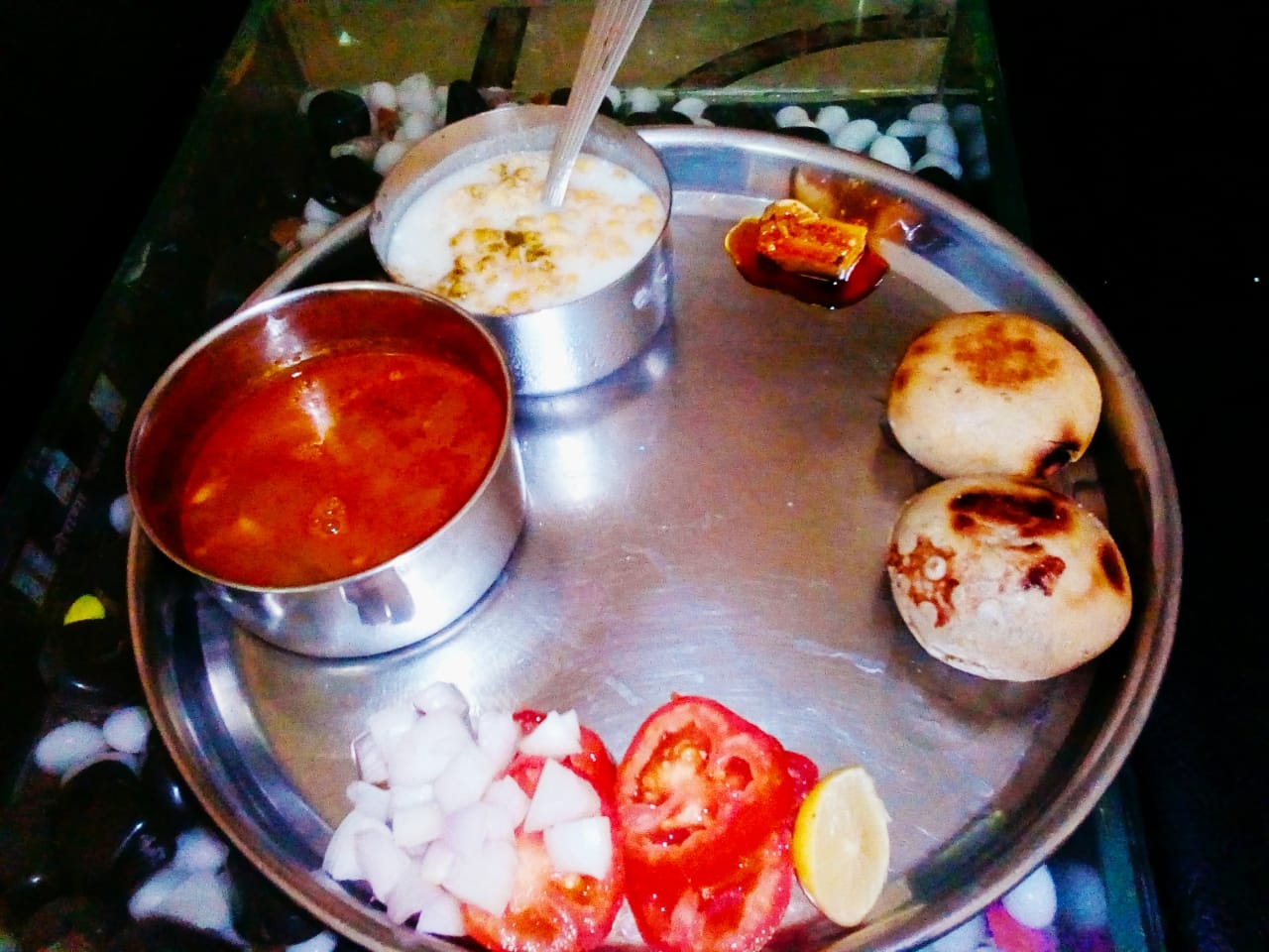 Rajasthani Thali | The India A metal tray displays a traditional Rajasthani thali with curry, lentils and flatbread as part of Indian cuisine.