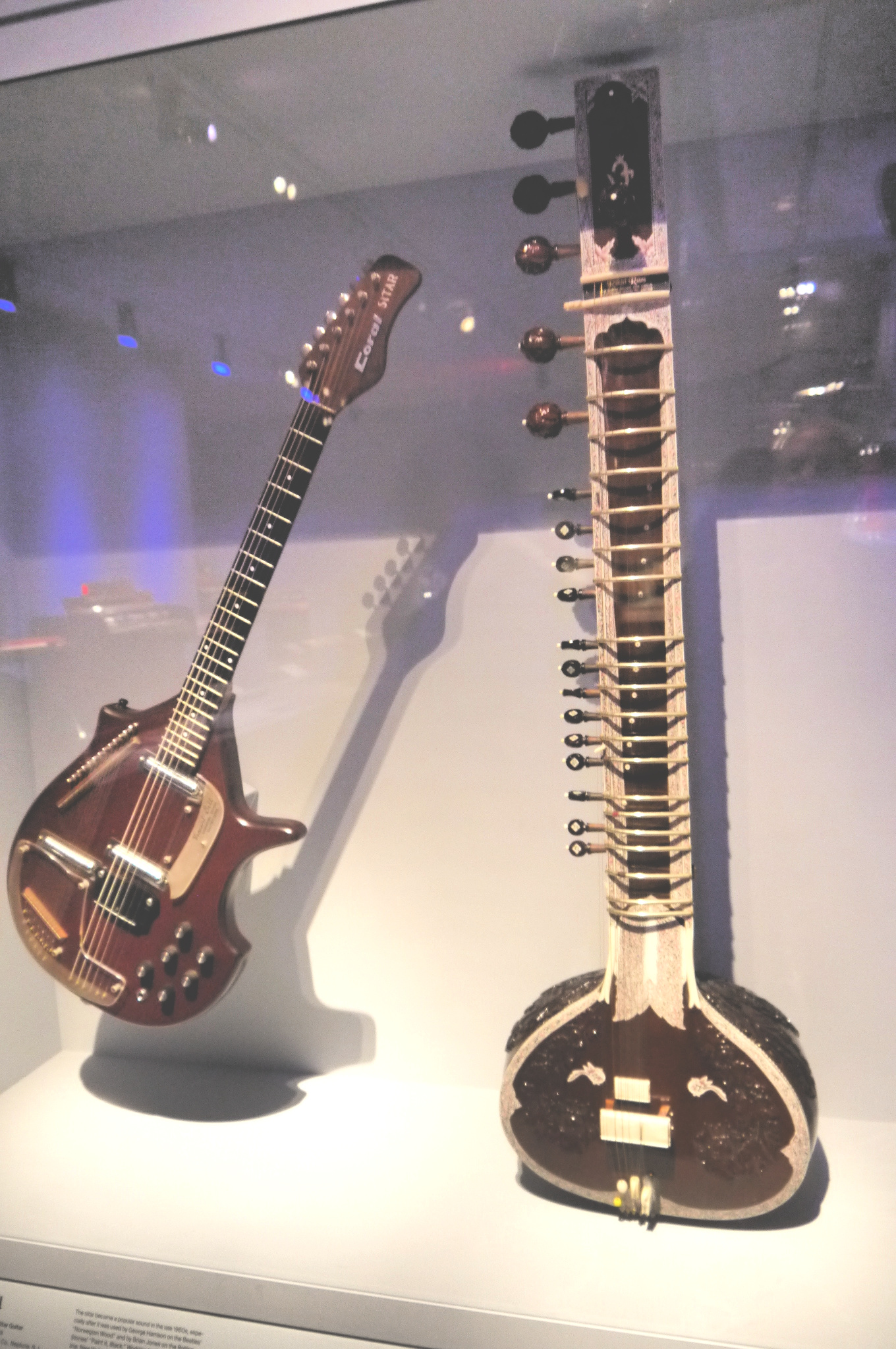 Ravi Shankar Sitar | The India Two stringed instruments, a guitar and sitar, are displayed as part of a museum exhibit about indian culture.