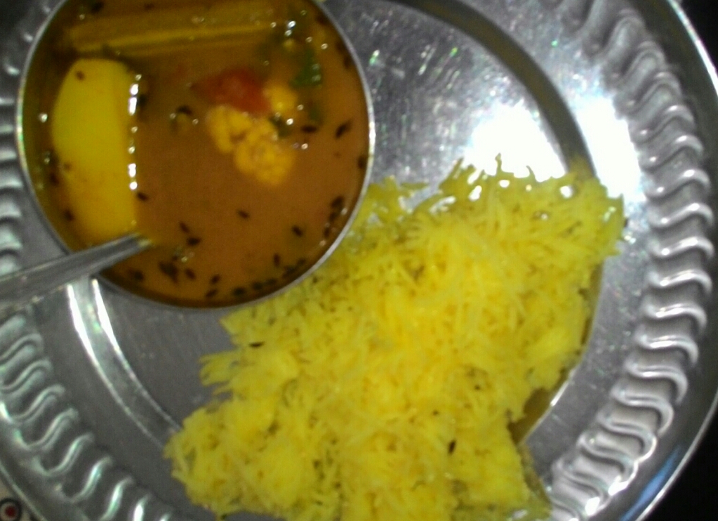 Sindhi Curry | The India A metal plate displays Sindhi Kadhi Chawal, a yellow dish with orange soup—a taste of Indian cuisine.