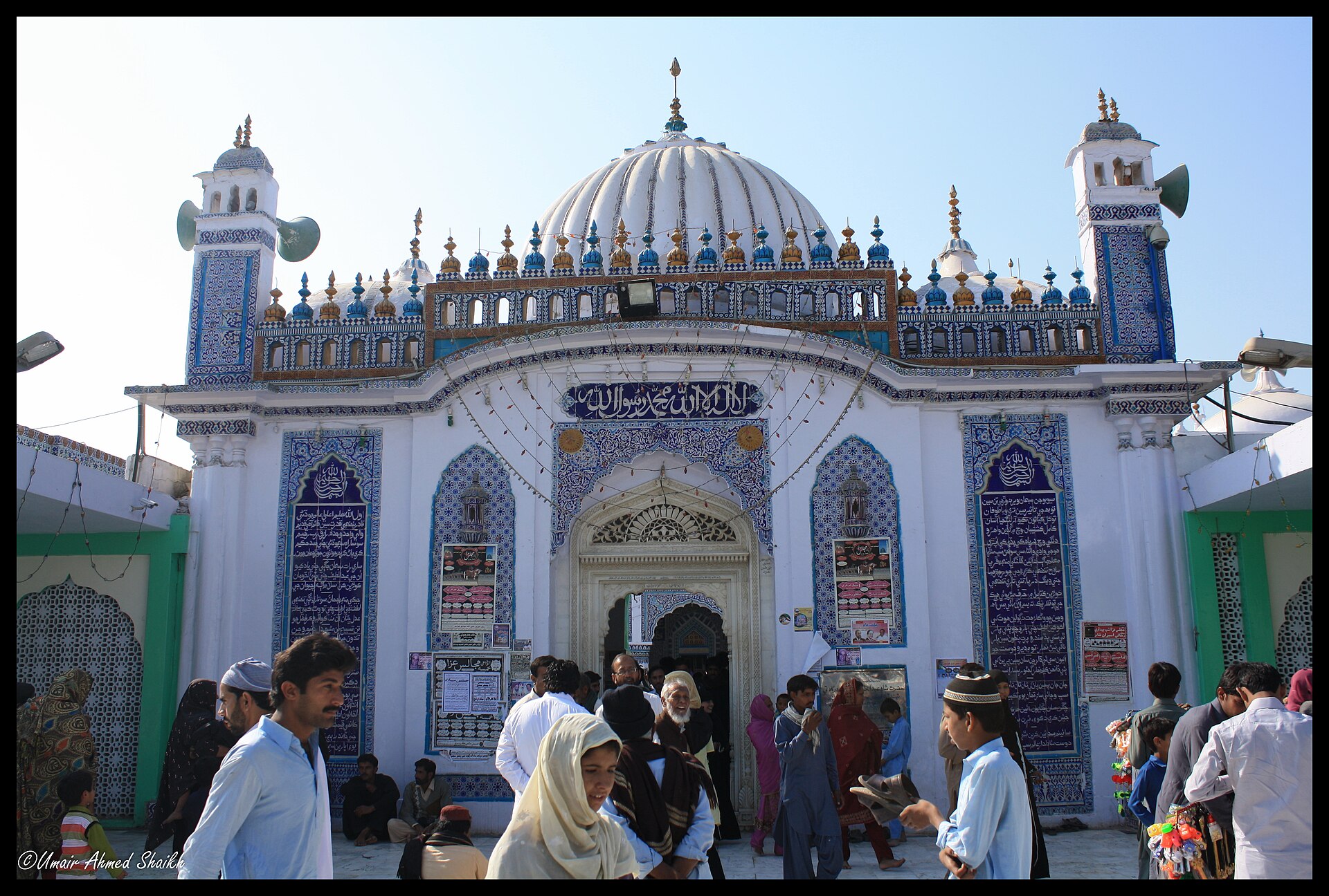 Sufi Shrine | The India A crowd gathers before a brightly decorated mosque, showcasing Islamic architecture in Pakistan.