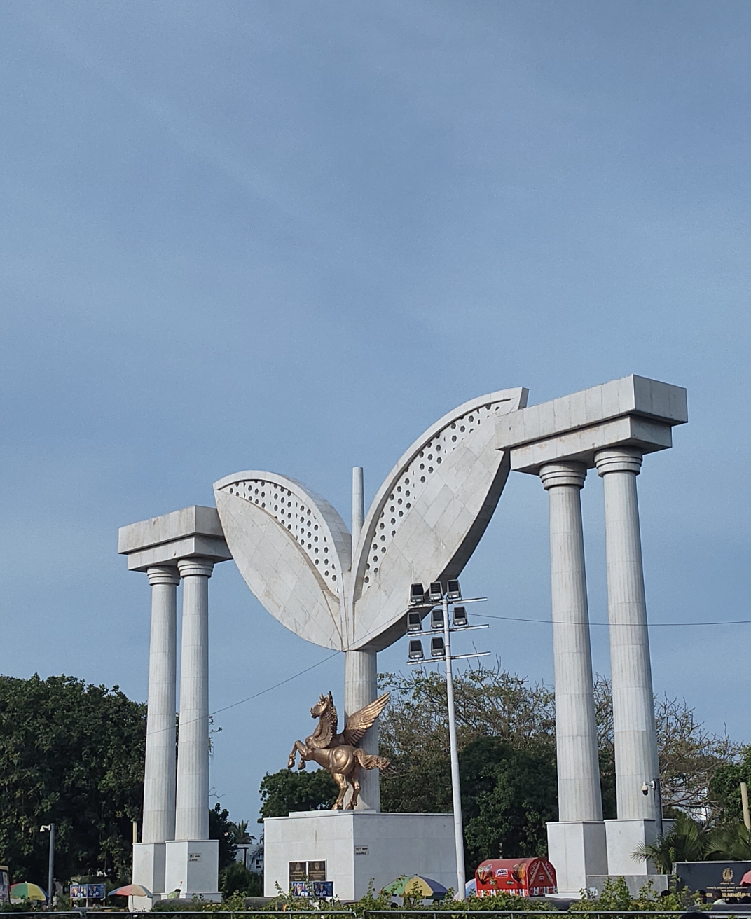 Tamil Cinema Stagecraft | The India A monument with a winged horse and butterfly arches stands at Marina Beach in Chennai, showcasing Tamil cinema's grand.